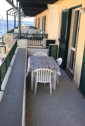 a table and chairs on a balcony with the ocean at CannetoMare in Canneto