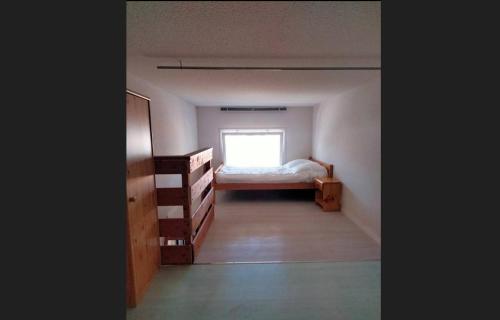 une petite chambre avec un lit et une fenêtre dans l'établissement Le plaisir de la corniche - Saint Hilaire de Riez, à Saint-Hilaire-de-Riez