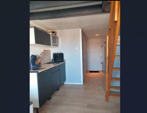 - une cuisine avec un évier et un escalier dans la chambre dans l'établissement Le plaisir de la corniche - Saint Hilaire de Riez, à Saint-Hilaire-de-Riez