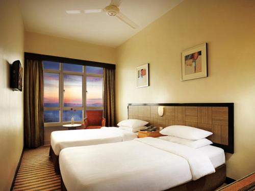 a hotel room with two beds and a window at Resorts World Genting - First World Hotel in Genting Highlands