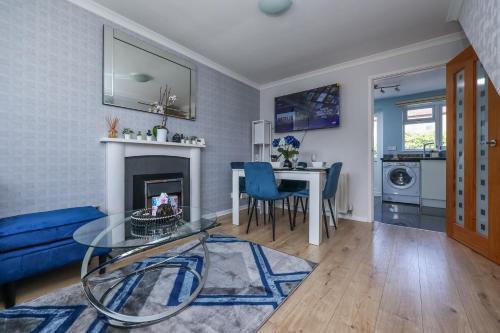 a living room with a blue couch and a table at 2 bed house Barton Green, Clifton Nottingham in Nottingham