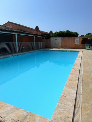 une piscine avec de l'eau bleue devant une maison dans l'établissement La Dolce Villa avec Piscine, à Zonza
