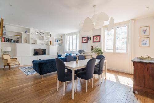 un salon avec une table, des chaises et un canapé dans l'établissement Veeve - Ethereal Light, à Paris