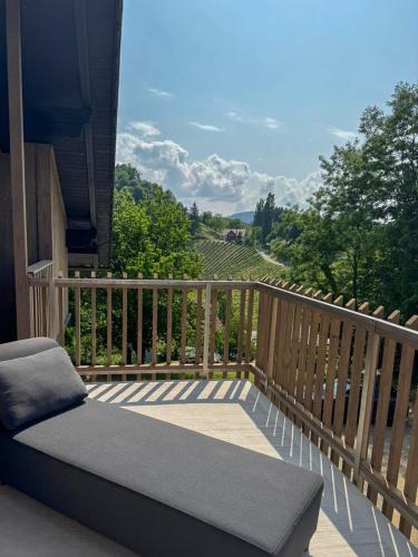a couch on a balcony with a view of a vineyard at Das Gretlnest - Premium Naturrefugium in Gamlitz