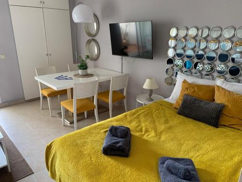 Un dormitorio con una cama amarilla y una mesa en BenalBeach Paradise, en Benalmádena
