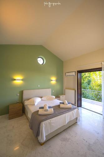 a bedroom with a large bed with two towels on it at Apartment inside Villa Daniela-Elegant & Luxury Style-Private Pool in Schinias