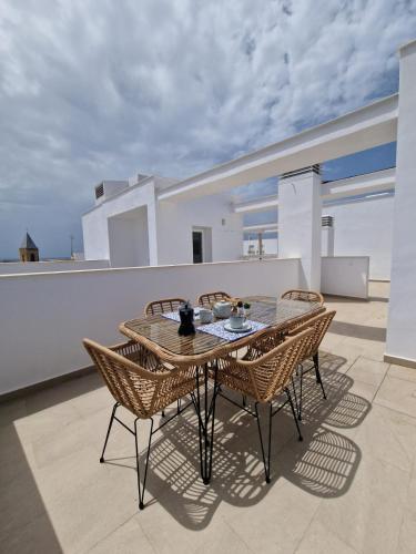 a table and chairs on top of a balcony at Bodega Centro Olehousing in Conil de la Frontera