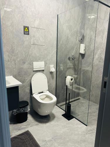 a bathroom with a toilet and a glass shower at Mayor Pension in Komárno