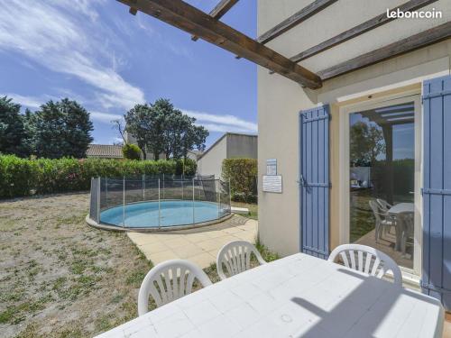 un patio avec une table et des chaises et une piscine dans l'établissement Villa de vacances, à Saint-Saturnin-lès-Avignon