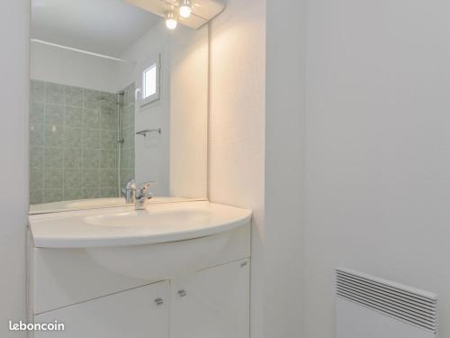 une salle de bain blanche avec un lavabo et un miroir dans l'établissement Villa de vacances, à Saint-Saturnin-lès-Avignon