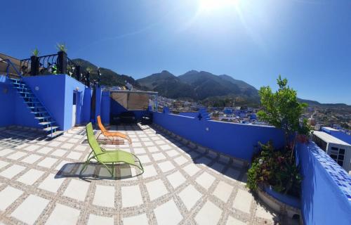 a green chair sitting on top of a roof at DAR Dunia Panoramic terrace in Chefchaouene