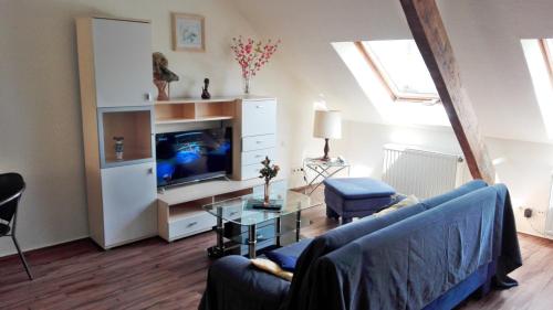 a living room with a blue couch and a tv at Gelder Dyck in Kevelaer