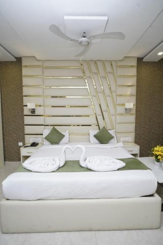 two white beds in a room with a wall at Hotel Aradhna Inn in Lucknow