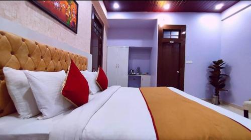 a bedroom with a large bed with red and white pillows at Hotel Aradhna Inn in Lucknow