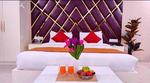 a bedroom with a large bed with a bowl of fruit on a table at Hotel Aradhna Inn in Lucknow