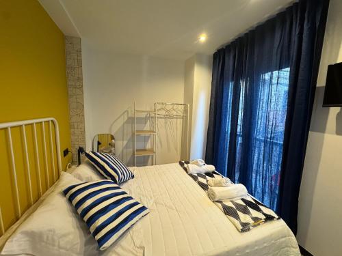 a bedroom with a bed with pillows and a window at Casa Faixa - Refugio en las Rías Baixas in Cangas de Morrazo