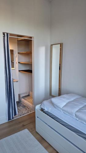 - une chambre avec un lit, un miroir et un placard dans l'établissement Appartement 2 chambres entièrement meublé et refait à neuf, à Toulouse