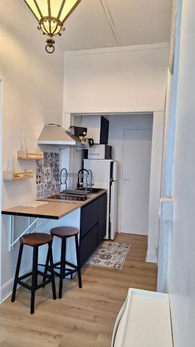 une cuisine avec un comptoir et deux tabourets dans l'établissement Appartement 2 chambres entièrement meublé et refait à neuf, à Toulouse