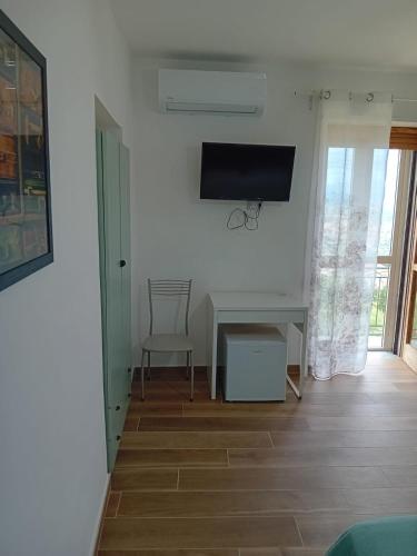 a living room with a desk and a tv on the wall at Cuore Verde del Cilento in Laureana Cilento