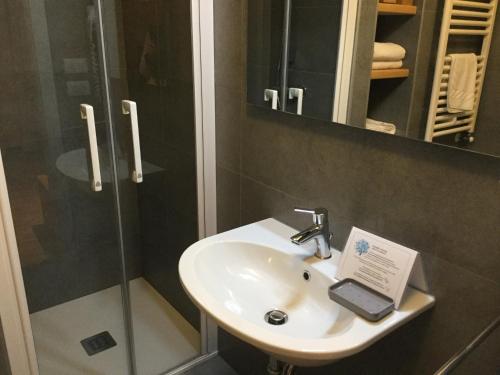 een badkamer met een wastafel en een mobiele telefoon. bij Albergo Belvedere in Sequals