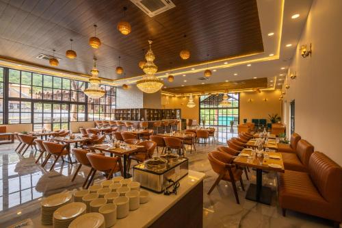 a restaurant with tables and chairs in a room at Axiom Resorts Luxury Cottages, Arambol in Arambol