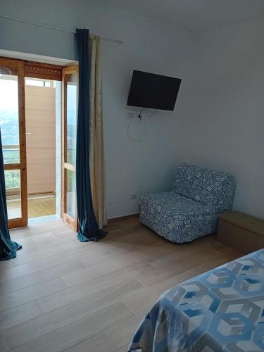 a bedroom with a bed and a chair and a television at Cuore Verde del Cilento in Laureana Cilento