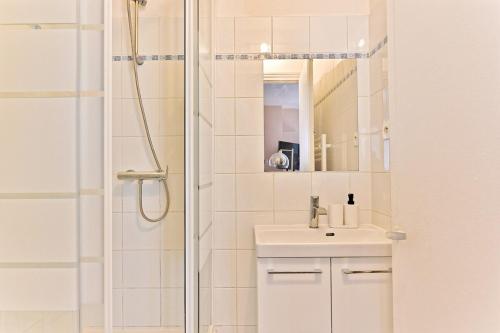 une salle de bain avec une douche, un lavabo et un miroir dans l'établissement Appartement proche de la Gare Montparnasse-II, à Paris
