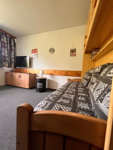 a bedroom with a bed and a flat screen tv at Studio de la Marmotte - Aime 2000 in Aime La Plagne