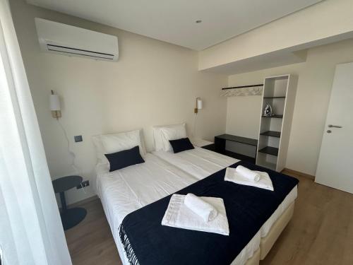 una camera da letto con un letto con due asciugamani sopra di Casa aOrta Apartments a Faro