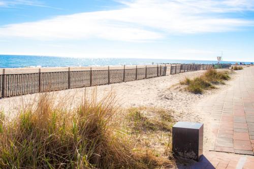 a walkway to the beach with the ocean in the background at Apartment Seesrauschen für 2-4 Personen mit Pool in Dahme