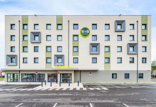 a large white building with a sign on it at B&B HOTEL Bourg-en-Bresse Viriat in Viriat