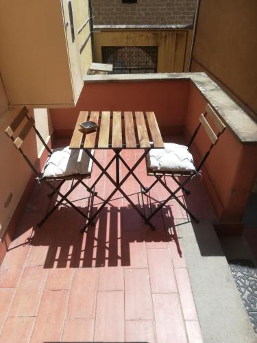 a picnic table and two chairs on a balcony at La Casa di Gioia in Tuscania