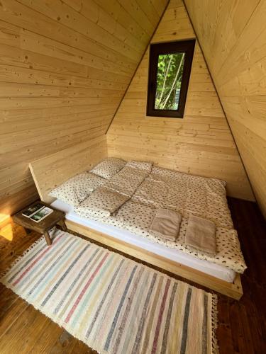 a bed in a wooden cabin with a window at Breb 220D glamping in Breb