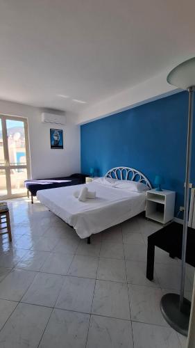 a bedroom with a large bed with a blue wall at CannetoMare in Canneto
