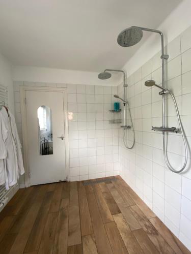 a bathroom with a shower and a wooden floor at B&B Bakenberg in Arnhem