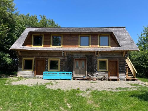 a log home with a blue front porch and doors at Breb 220D glamping in Breb