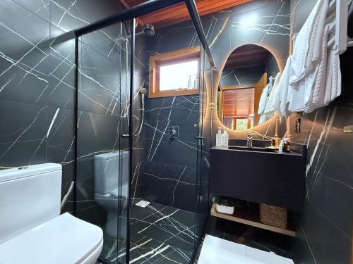 a bathroom with a shower and a toilet and a sink at Pousada Maçã Araucária in São Joaquim