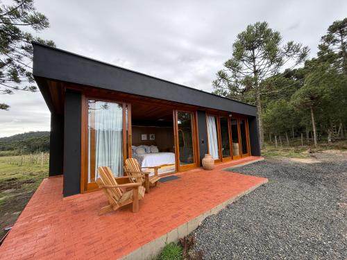 a black house with a bedroom and a bed at Pousada Maçã Araucária in São Joaquim