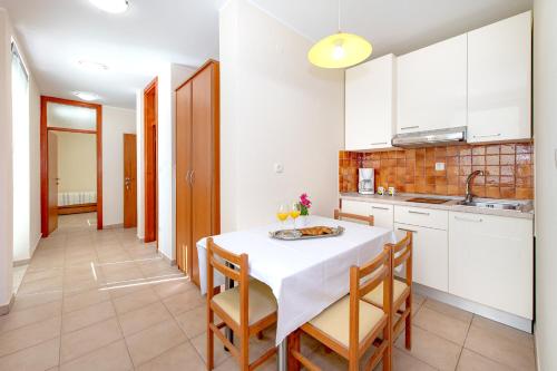 a kitchen with a table with chairs and a sink at Villa Lavanda in Primošten