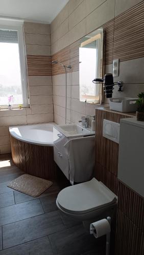 a bathroom with a tub and a toilet and a sink at Panoráma 4U in Tapolca
