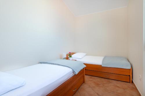 two twin beds in a room with white walls at Villa Lavanda in Primošten
