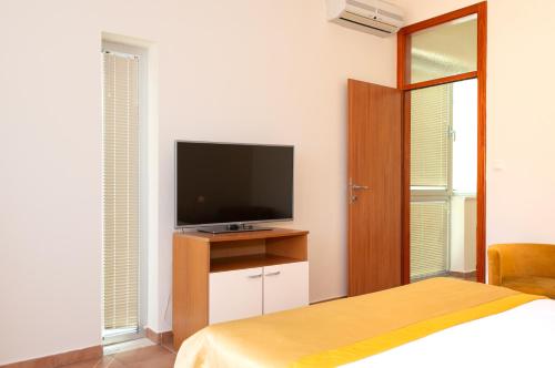 a bedroom with a flat screen tv and a bed at Villa Lavanda in Primošten