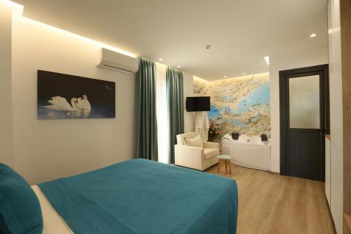 a bedroom with a blue bed and a living room at Ilio Boutique Hotel in Ksamil