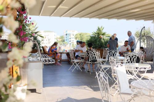 a group of people sitting at tables on a patio at Ilio Boutique Hotel in Ksamil