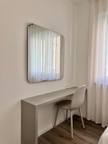 a desk with a chair and a mirror on a wall at 1Dest - Le Ginestre Serenity Home in Riva del Garda