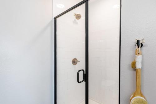 a shower stall with a glass door and a broom at Indie Deep Ellum in Dallas in Dallas