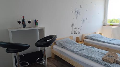 a bedroom with two twin beds and a stool at Panoráma 4U in Tapolca