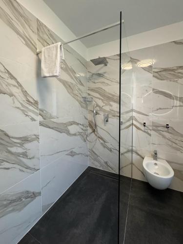 a bathroom with a sink and a glass shower at 1Dest - Le Ginestre Serenity Home in Riva del Garda