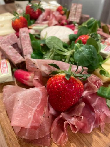 a plate of food with meat and a strawberry at Le Mas de Mirabel in Mirabel-aux-Baronnies
