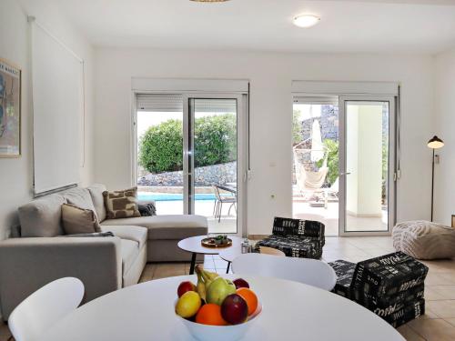 a living room with a table with a bowl of fruit at Villa Lawton - Magnificent sea & mountain views! in Epáno Kefalás